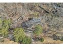 Aerial view of a home nestled among mature trees, showcasing the roof and the surrounding natural landscape at 6198 Rocky Creek Dr, Douglasville, GA 30135