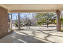 The property's covered carport features brick columns and an open view of the neighborhood street at 6198 Rocky Creek Dr, Douglasville, GA 30135