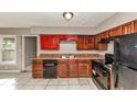 Functional kitchen featuring dark cabinetry, appliances, laminate countertops, and tile flooring at 2084 Snow Sw Rd, Atlanta, GA 30311