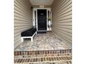 Covered front porch with decorative stone flooring, sitting bench, and decorative plants at 903 Creek Bottom Rd, Loganville, GA 30052