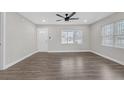Open living room featuring hardwood floors, large windows, and a ceiling fan at 1729 Spring Ne St, Conyers, GA 30012