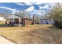 Brick home with separate garage and spacious backyard under a blue, cloudy sky at 1729 Spring Ne St, Conyers, GA 30012