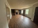 Cozy living room featuring a brick fireplace, built-in bookshelves, and wood flooring at 1789 Riverridge Nw Dr, Conyers, GA 30012