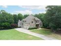 Beautiful two-story home featuring brick exterior, well-kept lawn, and attached garage at 8440 Woodland Brooke Trl, Cumming, GA 30028
