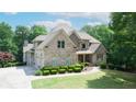 Stunning two-story brick home with manicured landscaping and a three-car garage at 8440 Woodland Brooke Trl, Cumming, GA 30028