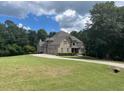 Spacious home featuring lush green lawn, mature trees and a circular driveway at 8440 Woodland Brooke Trl, Cumming, GA 30028