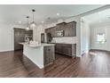 Well-lit kitchen with a large island, granite countertops, stainless appliances, and dark wood floors at 579 Collections Dr, Lawrenceville, GA 30043