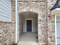 Inviting covered entry features a brick archway, leading to a stylish front door and well-lit foyer at 684 Sundial Ln, Mableton, GA 30126