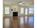Spacious living room featuring a fireplace, multiple windows, and glossy hardwood floors at 682 New England Way, Lawrenceville, GA 30046