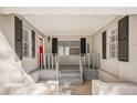 Covered front porch with red door, black shutters, and a cozy entrance at 3699 Narron Sw Dr, Atlanta, GA 30331