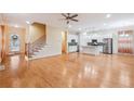 Open-concept living room with staircase, hardwood floors, and modern white kitchen with island at 33 Hardpan Aly, Marietta, GA 30066
