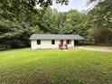 Charming single-story home with a well-manicured lawn and inviting red front door at 4776 Ballew Dr, Powder Springs, GA 30127