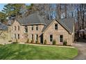 Exterior view of brick home featuring mature landscaping, well-kept lawn, and private driveway at 5956 Henley Dr, Powder Springs, GA 30127