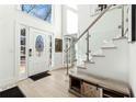 Bright foyer featuring hardwood floors, staircase with glass railing, and stylish décor at 5956 Henley Dr, Powder Springs, GA 30127