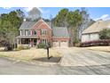 Beautiful two-story brick house with attached two-car garage, charming porch, and manicured front lawn at 616 Redwood Ln, Canton, GA 30114