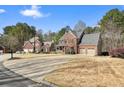 A well-maintained street with two-story brick homes, mature trees, and lush green lawns at 616 Redwood Ln, Canton, GA 30114