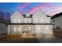 Beautiful two-story modern farmhouse with white siding and a lovely dusk sky backdrop at 929 Keystone Dr, Woodstock, GA 30188