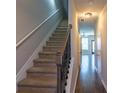 View of a carpeted stairway with wooden handrail leading to the upper level of the home at 3293 Pennington Dr, Stonecrest, GA 30038