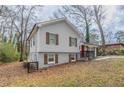 Charming home featuring a carport, red front door, grey siding, and painted brick foundation at 2304 Wesley Chapel Rd, Decatur, GA 30035
