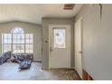 Entryway featuring a decorative front door, damaged walls, and modern wood-look flooring at 6381 Phillips Creek Dr, Lithonia, GA 30058