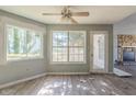 Bright living room with stone fireplace, ceiling fan, and lots of natural light from large windows at 6381 Phillips Creek Dr, Lithonia, GA 30058