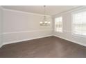 Spacious dining room with hardwood floors, elegant chandelier and bright windows at 951 Olmsted Ln, Johns Creek, GA 30097