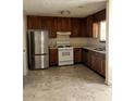 Functional kitchen with stainless steel refrigerator, gas range, and dark wood cabinetry at 3636 Hopkins Ct, Powder Springs, GA 30127