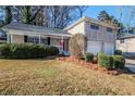 Beautifully landscaped front yard with a charming brick facade and inviting red front door at 2236 Chestnut Hill Cir, Decatur, GA 30032