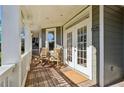 Inviting covered front porch featuring rocking chairs and double french doors at 1898 Woodland Hills Nw Ave, Atlanta, GA 30318