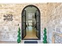 Elegant entryway with arched double doors, stone walls, and a view into the bright, open interior at 2634 Greenes Ln, Powder Springs, GA 30217