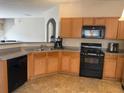 The kitchen features wood cabinets, black appliances and a gray countertop at 3134 Imperial Sw Cir, Atlanta, GA 30311