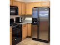 Kitchen featuring stainless steel refrigerator, black range, microwave, and wooden cabinetry at 3134 Imperial Sw Cir, Atlanta, GA 30311