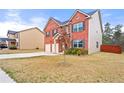 Side view of a beautiful brick home showcasing a spacious driveway and manicured lawn at 1695 Beckworth Ln, Hampton, GA 30228