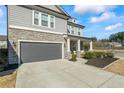 Charming two-story home with stone accents, a gray garage door, and manicured landscaping at 500 Anfield Dr, Woodstock, GA 30188