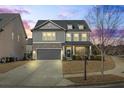 Charming two-story home with stone accents, a gray garage door, and manicured landscaping at dusk at 500 Anfield Dr, Woodstock, GA 30188