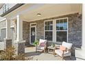 Inviting front porch with chairs, stone accents, and a welcoming entrance to the home at 500 Anfield Dr, Woodstock, GA 30188