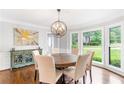 Bright dining room with hardwood floors, a modern chandelier, and large windows overlooking the yard at 7010 Hunters Knl, Atlanta, GA 30328