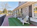 Inviting front porch with a custom welcome sign, artificial grass, white Adirondack chairs, and decorative accents at 5065 Sunrise Ln, Cumming, GA 30041