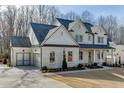 Stunning brick home featuring an attached garage and well-maintained lawn with beautiful architectural details at 4348 Hamilton Mill Rd, Buford, GA 30518