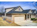 A beautiful exterior elevation showcasing brick accents, a well-maintained lawn, and a two-car garage at 563 Carleton Pl, Locust Grove, GA 30248