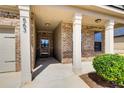 Inviting front porch with classic columns, brick accents, and a well-manicured shrub at 563 Carleton Pl, Locust Grove, GA 30248