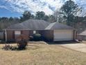 Traditional brick home featuring an attached garage, well-kept lawn, and mature trees for added curb appeal at 355 Tait Rd, Stockbridge, GA 30281