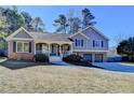 Charming two-story home featuring a brick and gray siding exterior, well-manicured lawn, and a two-car garage at 3736 Rainbow Cir, Snellville, GA 30039