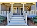 Inviting front porch with white railings and steps leading to the front door with a charming round window at 3736 Rainbow Cir, Snellville, GA 30039