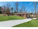 Long driveway leads to a classic brick home with lush greenery and mature trees at 3250 N Embry Cir, Atlanta, GA 30341