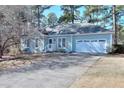 Charming light blue home featuring a manicured lawn and a two-car garage, creating a welcoming curb appeal at 4020 Winchester Way, Loganville, GA 30052