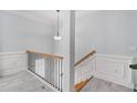 Elegant staircase with wooden handrail and white wainscoting, adding a touch of sophistication at 5341 Concordia Se Pl # 8, Mableton, GA 30126