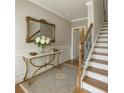Elegant foyer with a decorative mirror, hardwood floors, staircase, and classic wainscoting at 146 Rowan Ave, Alpharetta, GA 30009