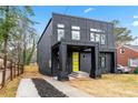Contemporary two-story home featuring a sleek black facade and a vibrant yellow front door at 2402 Lynn Iris Dr, Decatur, GA 30032