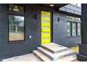 Close-up of a striking yellow front door with glass panels, set against a black brick exterior at 2402 Lynn Iris Dr, Decatur, GA 30032